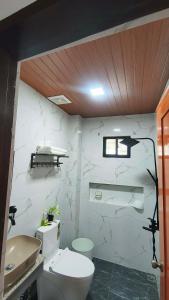 a white bathroom with a toilet and a sink at Engil's Studio in San Jose Dinagat Islands Philippines in Bulawan +7 photos