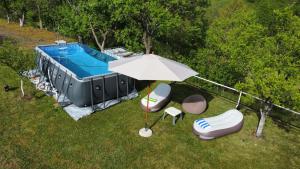 an umbrella and some chairs and a swimming pool at LOPATE mountain stone house in Lopate +111 photos