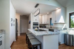 a kitchen with white cabinets and a counter with stools at 2264 Seascape Crt. in Seabrook Island