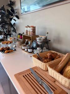 a kitchen counter with baskets of bread and other foods at Hôtel Valencia in Hendaye +42 photos