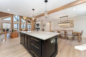 a kitchen and dining room with a large island in a house at Luxury Log Cabin with lake view in Black Mountain