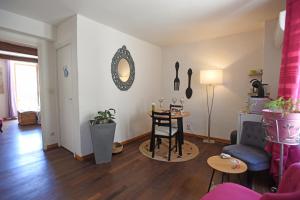 a living room with a table and a chair at L'AMARILYS chambre d'hôte au coeur du village, terrasse avec vue sur le château in Châteauneuf-du-Pape