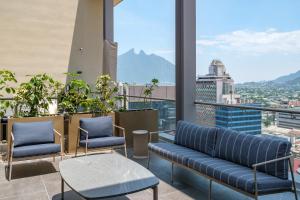 a balcony with chairs and a view of a city at Nido x Downtown MTY in Monterrey