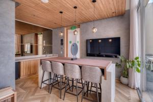 a kitchen with a wooden table and bar stools at Nido x Downtown MTY in Monterrey