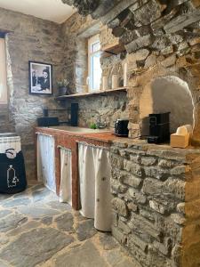 a stone kitchen with a counter and a stone wall at La Antica Torre in Sasseta
