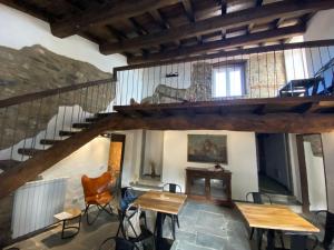 a room with a staircase and wooden tables and chairs at La Antica Torre in Sasseta