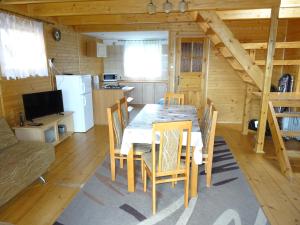a dining room with a table and chairs in a cabin at Domek Bieszczady Wolkowyja 2 nad Solina in Wołkowyja