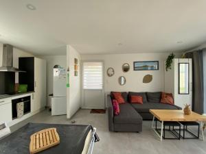 a living room with a couch and a table at Gite du Becquet in Le Rozel