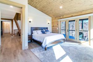 a bedroom with a large bed in a room with windows at Luxury Log Cabin with lake view in Black Mountain