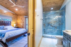 a bedroom with a bed and a glass shower at Luxury Log Cabin with lake view in Black Mountain +89 photos