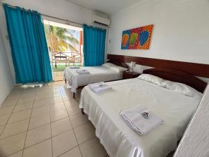 a hotel room with two beds and a window at Hotel Las Terrazas de Bonanza in Zorritos +59 photos