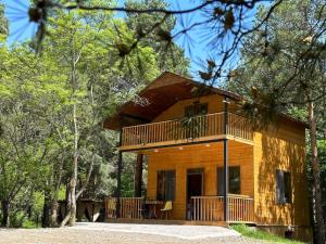 a cabin in the woods with a wrap around deck at Trichk Resort in Goris