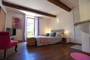 a bedroom with a bed and a large window at L'AMARILYS chambre d'hôte au coeur du village, terrasse avec vue sur le château in Châteauneuf-du-Pape