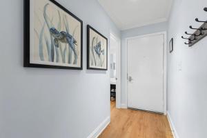 a hallway with paintings on the wall and a door at 1327 Pelican Watch Villa in Seabrook Island +34 photos