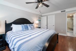 a bedroom with a large bed with blue and white stripes at 1307 Pelican Watch Villa in Seabrook Island