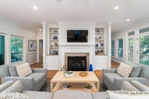 a living room with a fireplace and a tv at 1006 Crooked Oaks in Seabrook Island +37 photos