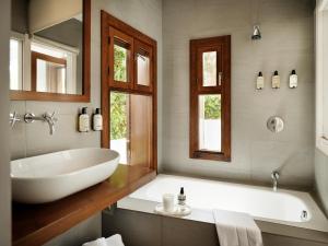 a bathroom with a large white tub and a sink at Hotel Los Patios - Parque Natural in Rodalquilar