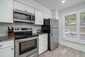 a kitchen with stainless steel appliances and white cabinets at 1147 Summerwind Cottage in Seabrook Island