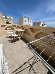 a table and chairs on the roof of a building at Leon Lux Apartment in Perivolos +77 photos