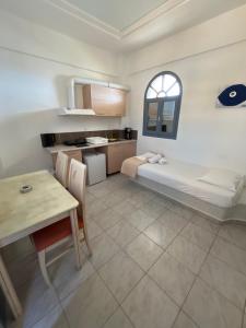 a room with a bed and a table and a kitchen at Leon Lux Apartment in Perivolos