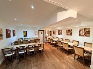 a dining room with wooden tables and chairs at Elysee Hyde Park in London