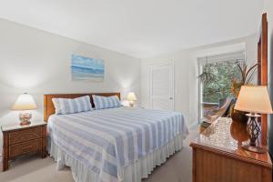 a white bedroom with a bed and a window at 1340 Pelican Watch Villa in Seabrook Island