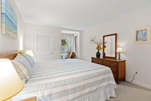 a white bedroom with a bed and a mirror at 1340 Pelican Watch Villa in Seabrook Island +14 photos