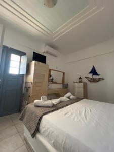a bedroom with a large white bed with towels on it at Leon Lux Apartment in Perivolos