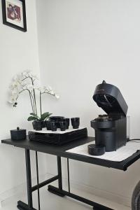a coffee maker on a table with cups and flowers at Apartmán u pilotky in Poděbrady +13 photos