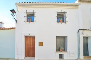 a white building with two windows and a door at Apartamentos La Gruta de Aracena 3 in Aracena