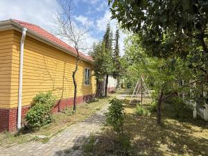 a yellow house with a pathway next to a house at Gabala Homes Musa in Gabala