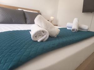 a bed with two towels on top of it at George Arhagelos Villa in Archángelos