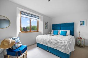 a bedroom with a blue bed and a chair at Pitstop in Dartmouth +47 photos