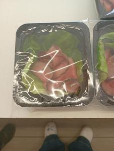 a person standing on a shelf with meat and vegetables at Le colline in corso Bra in Alba +5 photos