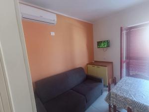a living room with a couch and a window at Effegi Casa Vacanze in Mandatoriccio Marina