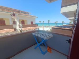 a blue table on a balcony with a view of the beach at Effegi Casa Vacanze in Mandatoriccio Marina