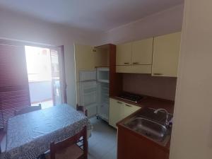 a small kitchen with a table and a sink at Effegi Casa Vacanze in Mandatoriccio Marina