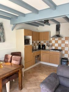a large kitchen with wooden cabinets and a table at Verba in Hollum