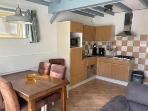 a kitchen with a table and a dining room at Verba in Hollum