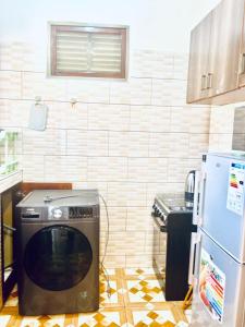 a kitchen with a refrigerator and a microwave at Robchen homes in Entebbe +10 photos