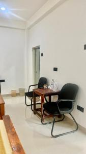a room with two chairs and a wooden table at Woodsy Villa in Sigiriya