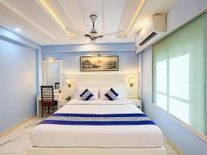 a bedroom with a large bed with blue walls at Blue Lily Beach Resort in Puri +36 photos
