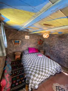 a bedroom with a bed in a room with a brick wall at The Mud House in Tamraght Ouzdar