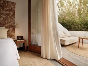 a bedroom with a bed and a couch and a window at Hotel Los Patios - Parque Natural in Rodalquilar