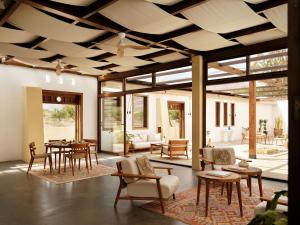 a living room with wooden ceilings and tables and chairs at Hotel Los Patios - Parque Natural in Rodalquilar
