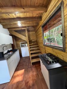 a kitchen and stairs in a log cabin at Cabanas da zimba in Imbituba