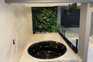 a bathroom with a black sink and a green wall at Anonimato Hotel in Santos