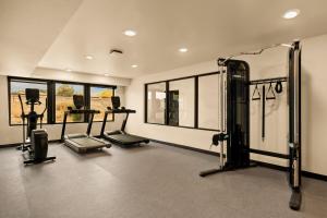 a gym with cardio equipment in a room with windows at LivAway Suite Tucson in Tucson