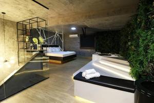 a bathroom with two beds and a plant at Anonimato Hotel in Santos