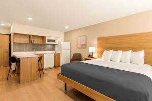 a hotel room with a bed and a kitchen at LivAway Suite Tucson in Tucson